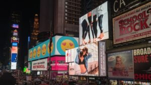 Colorful billboards light up New York City's iconic Times Square at night, with vibrant ads and bustling crowds.