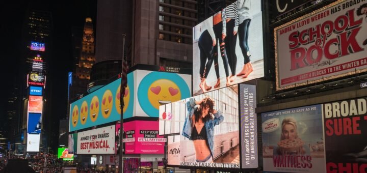 Colorful billboards light up New York City's iconic Times Square at night, with vibrant ads and bustling crowds.
