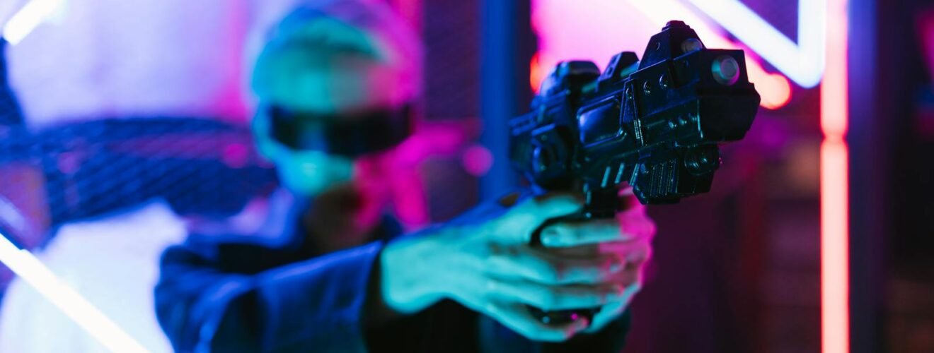 A woman in cyberpunk fashion holding a futuristic weapon against a neon backdrop.