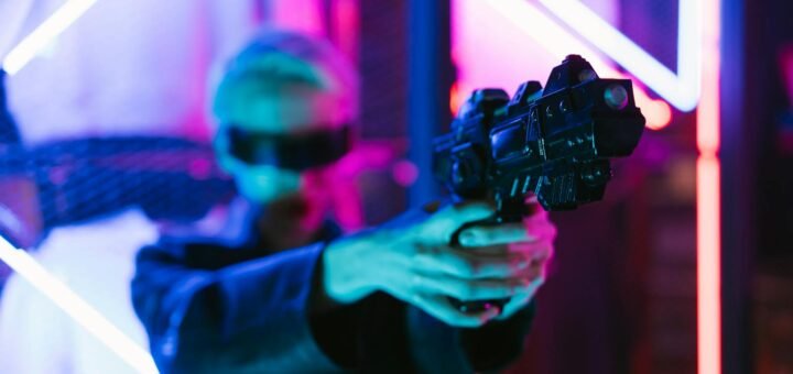 A woman in cyberpunk fashion holding a futuristic weapon against a neon backdrop.
