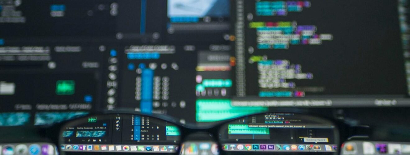 Eyeglasses reflecting computer code on a monitor, ideal for technology and programming themes.