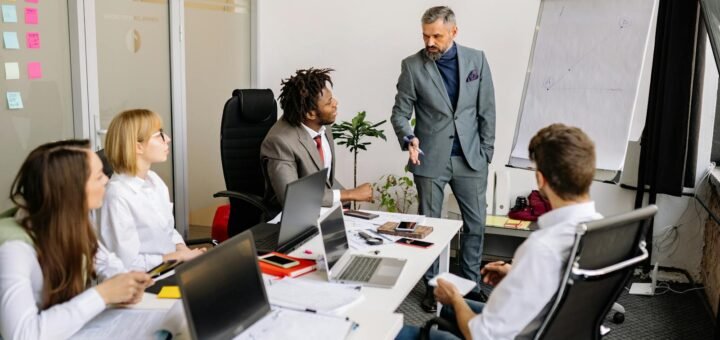 Corporate team in a modern office, engaged in a discussion with diverse colleagues.