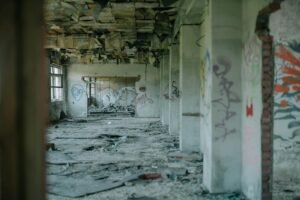An abandoned building interior with graffiti, showcasing decay and urban desolation.