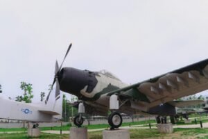A camouflaged airplane is displayed outdoors.