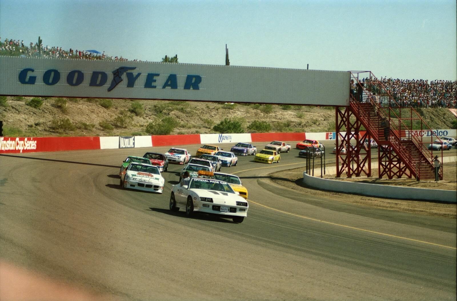 High-speed NASCAR race cars navigating a turn during a thrilling race at Avondale track.
