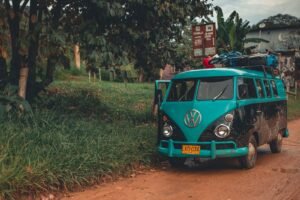 A classic Volkswagen van parked on a scenic rural road with lush greenery.