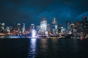 Modern cityscape illuminated at night reflecting on water