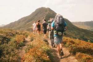 A group of people hiking on a trail toward a large mountain peak