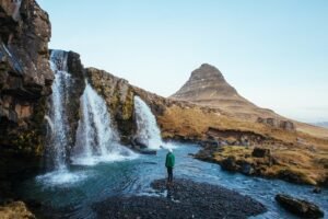 man standing near waterfalls