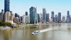 A ferry boat traveling on the Brisbane River beneath the Kurilpa Bridge in Brisbane